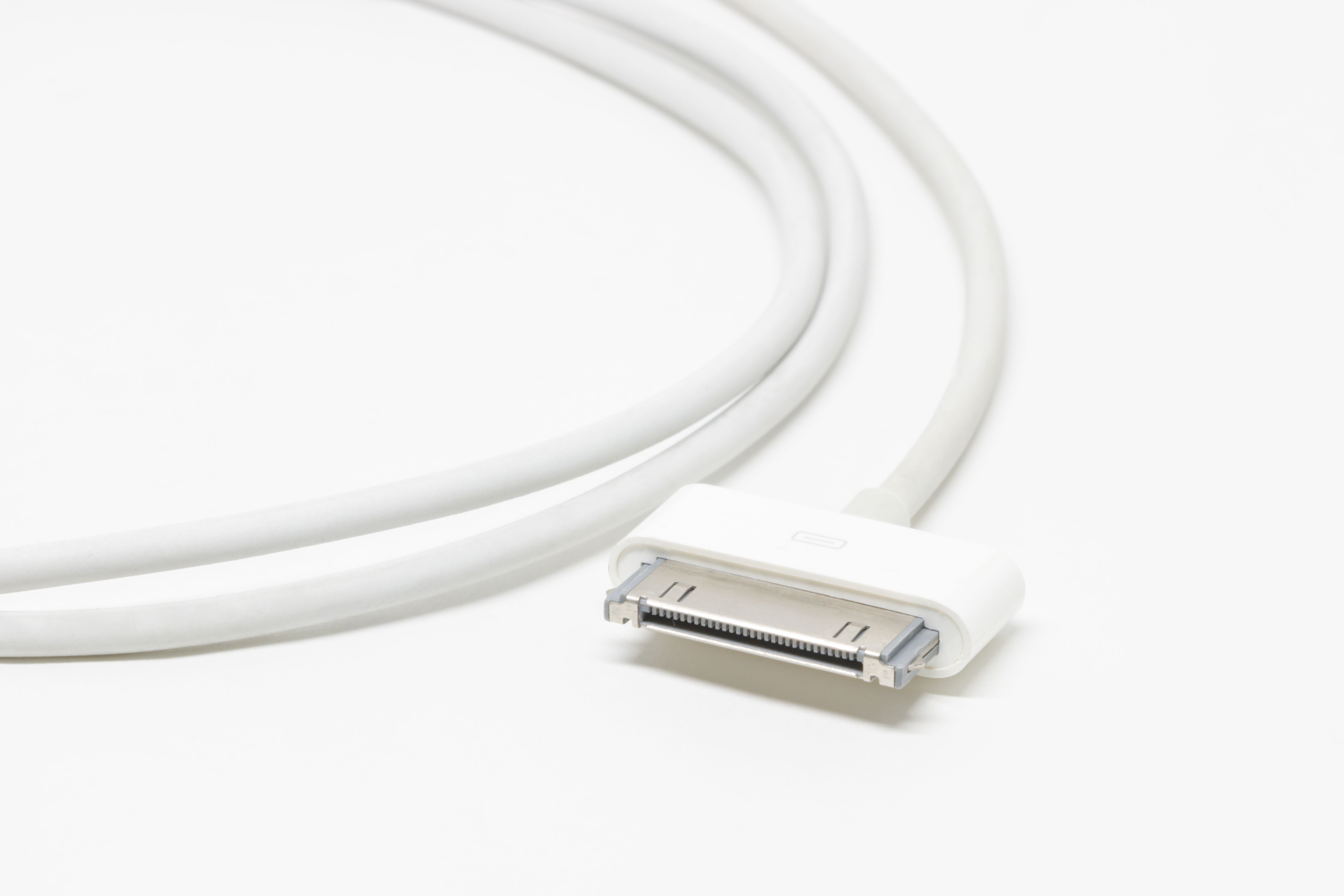 Wireless earbuds case open on a clean white desk showing the charging contacts