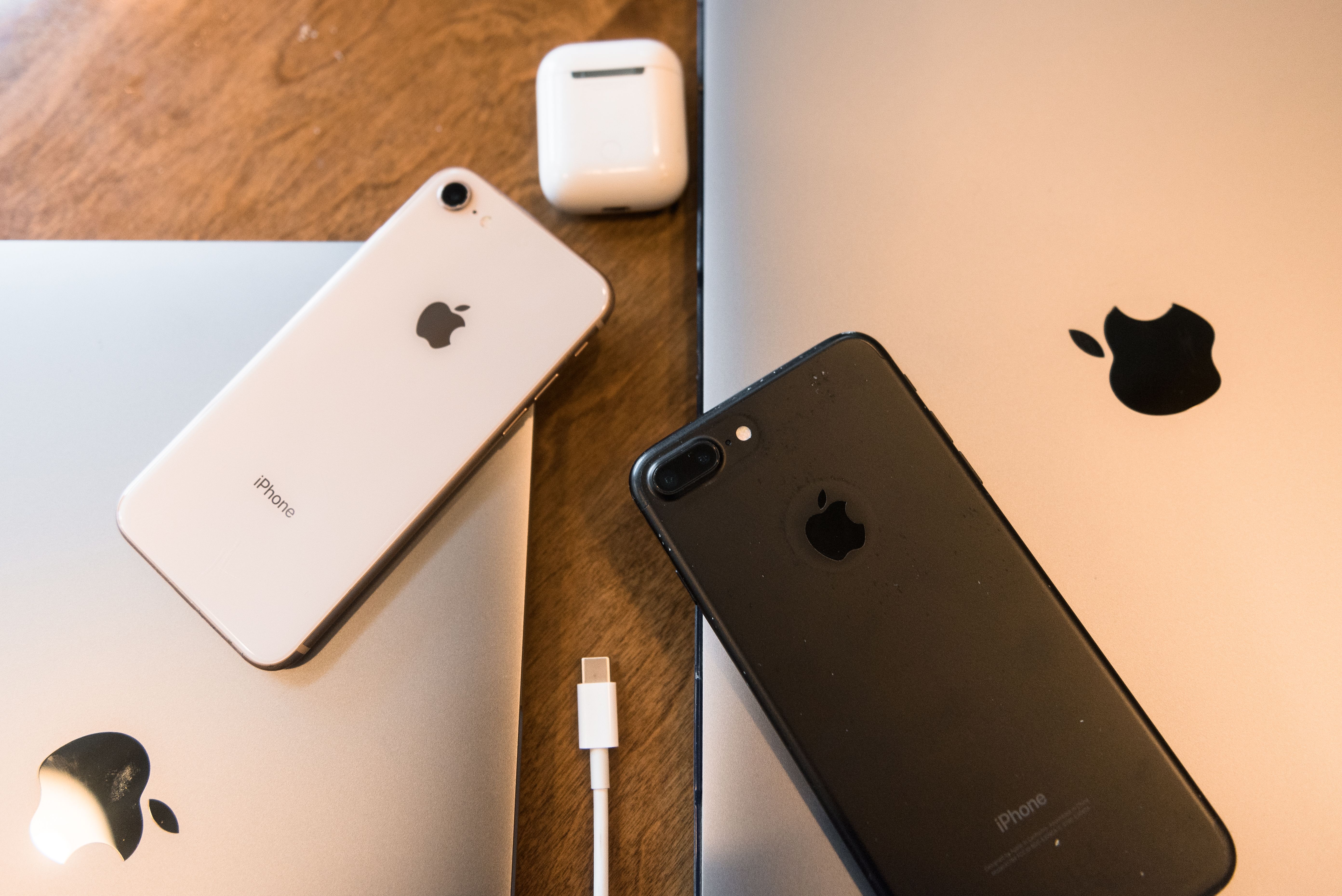 Flat lay of tech accessories including earbuds and a phone on a marble surface